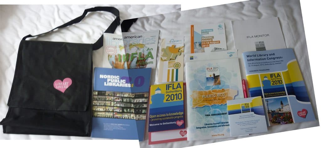 Eine Tasche mit "Bibliotheksliebhaber" drauf und einige Bühcher auf einem Bett.