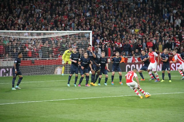 Fußballspieler auf dem Feld mit einer großen Menge hinter ihnen.