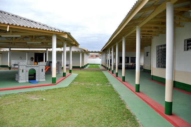 Schutzräume mit Säulen und Zimmern, umgeben von einer Grasfläche.