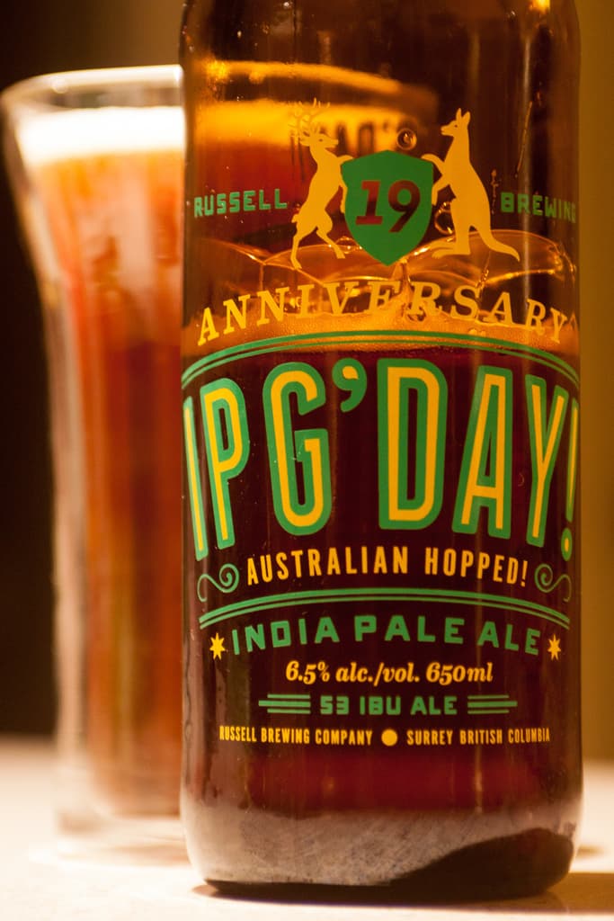 Eine Weinflasche und ein Weinglas stehen auf einem Tisch.