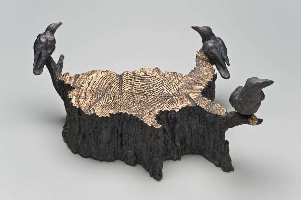 Ein hölzernes Objekt mit Vogeldarstellungen in der Mitte.