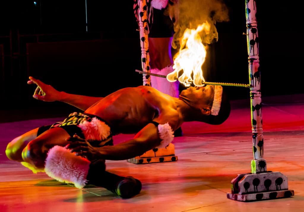 Eine Person schaut auf ein Feuer, das auf einem Stab befestigt ist, der an Stangen befestigt ist.