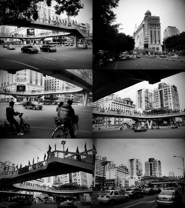 Autos und Fahrräder unter einer Brücke, mit ein paar Fahrzeugen vor einem Gebäude.