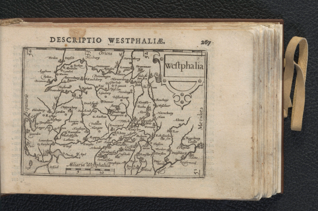 Ein aufgeschlagenes Buch mit einer detaillierten Karte von Westfalen auf schwarzem Hintergrund.