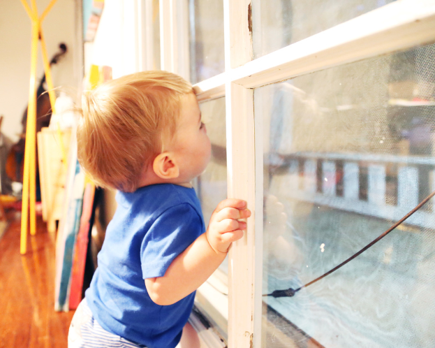 Ein Junge in einem blauen T-Shirt steht in der Nähe eines Glases mit Führungspersonen und anderen Gegenständen im Hintergrund.