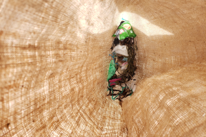 Nahaufnahme eines Stücks recycelten Papiers auf einem Tisch mit einem Jutestoff im Hintergrund.