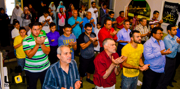 Menschen beten in einem Raum mit Text in der linken unteren Ecke.