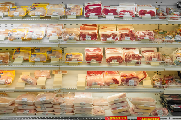Ein gut organisierter Supermarktboden mit verschiedenen ordentlich angeordneten Fleischsorten und sichtbaren Preisschildern.