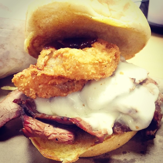 Verschiedene Brotsorten und ein Behälter mit Sahne auf einem Tisch.