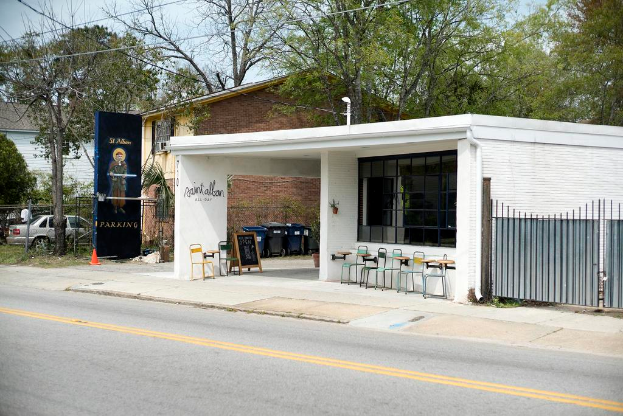 Ein Restaurant an einer Straße gelegen mit Bäumen im Hintergrund.