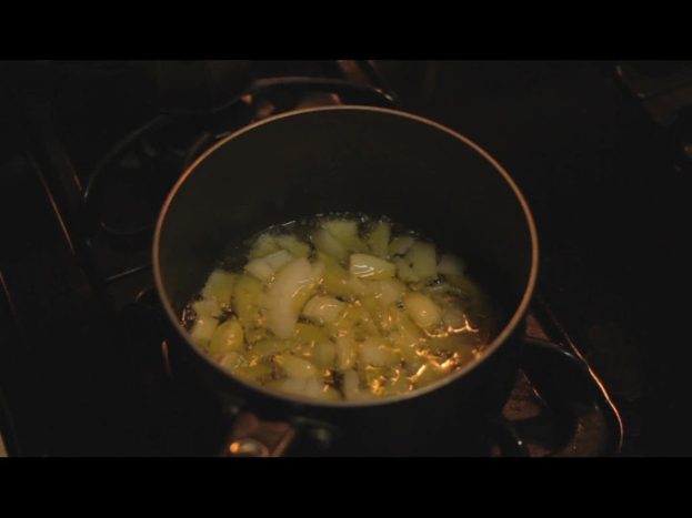 Ein Herd mit einem Gefäß, in dem Essen darauf gekocht wird.