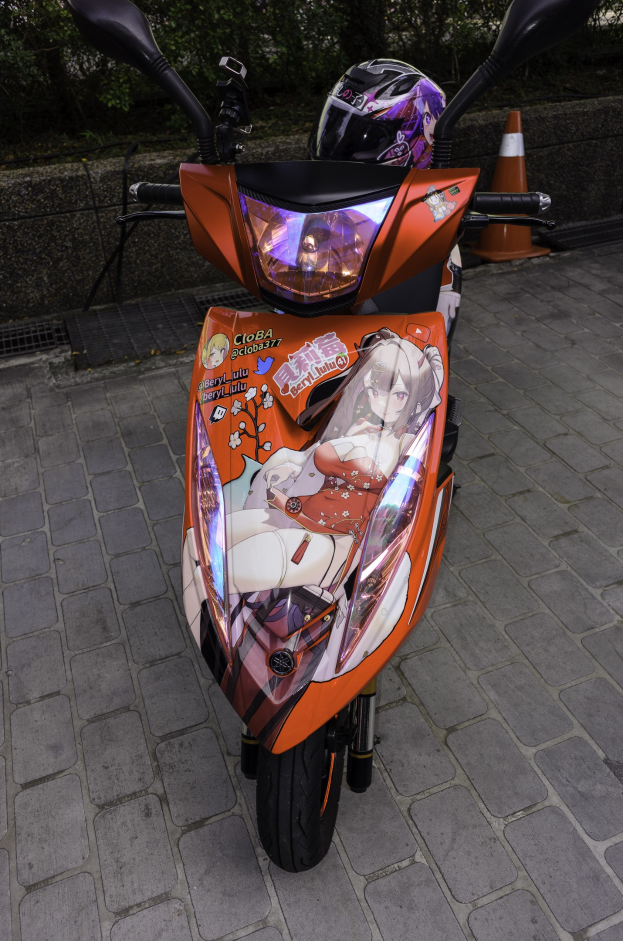 Ein oranger E-Scooter mit Helm darauf, der auf der Straße geparkt ist, mit einem Verkehrskegel, einer Wand und Bäumen im Hintergrund.