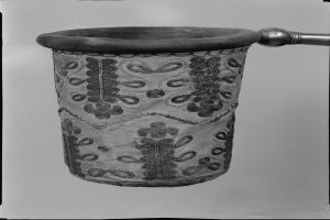 Ein Schwarz-Weiß-Foto eines Stoffabfalleimers mit Griff.