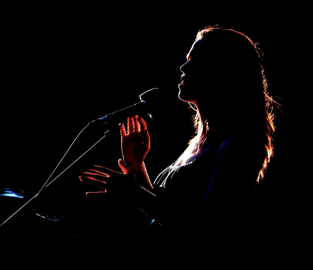 Ein Mädchen singt in ein Mikrofon.