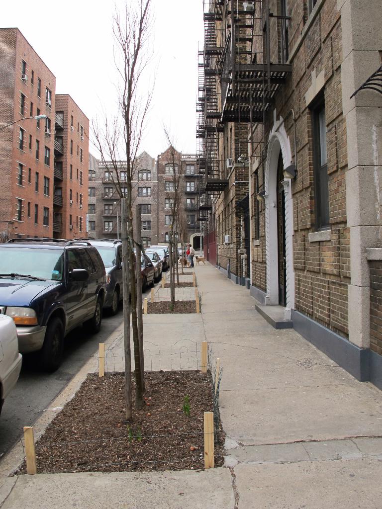 Eine spärlich bebaute Stadtlandschaft mit wenigen Autos und Gebäuden in der rechten Ecke und einigen anderen Gebäuden in der linken Ecke.