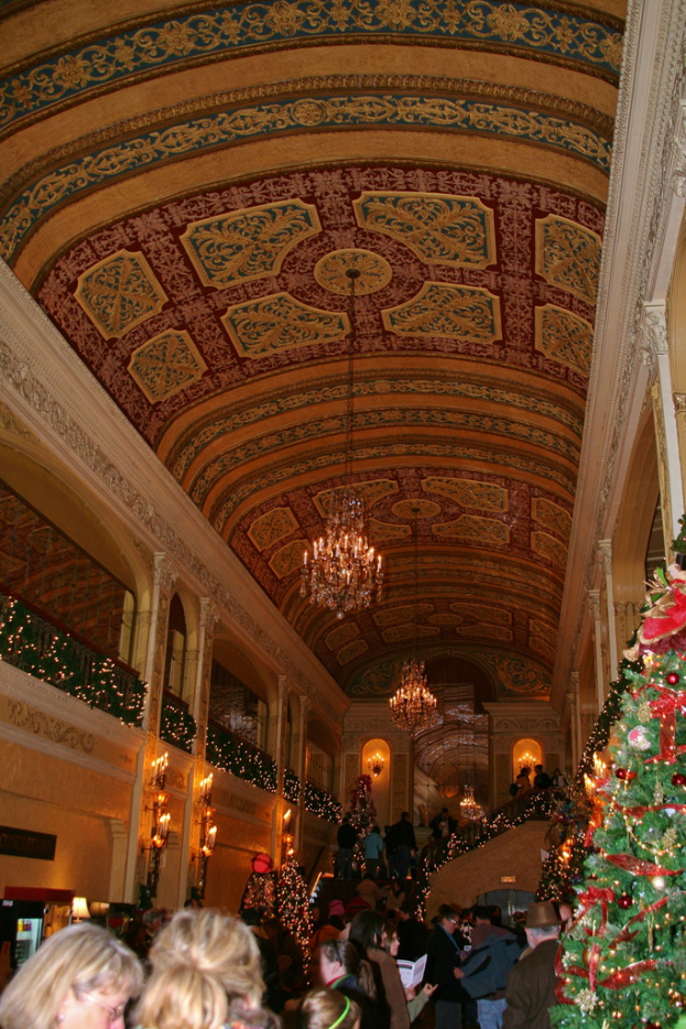 Eine Gruppe von Menschen in einem Raum mit Pflanzen, Lampen und Leuchten an der Decke.