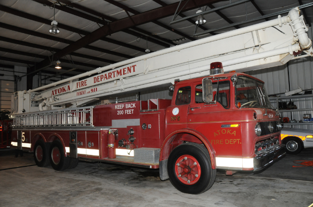 Ein Feuerwehrauto steht in einer großen Lagerhalle mit Deckenbeleuchtung.