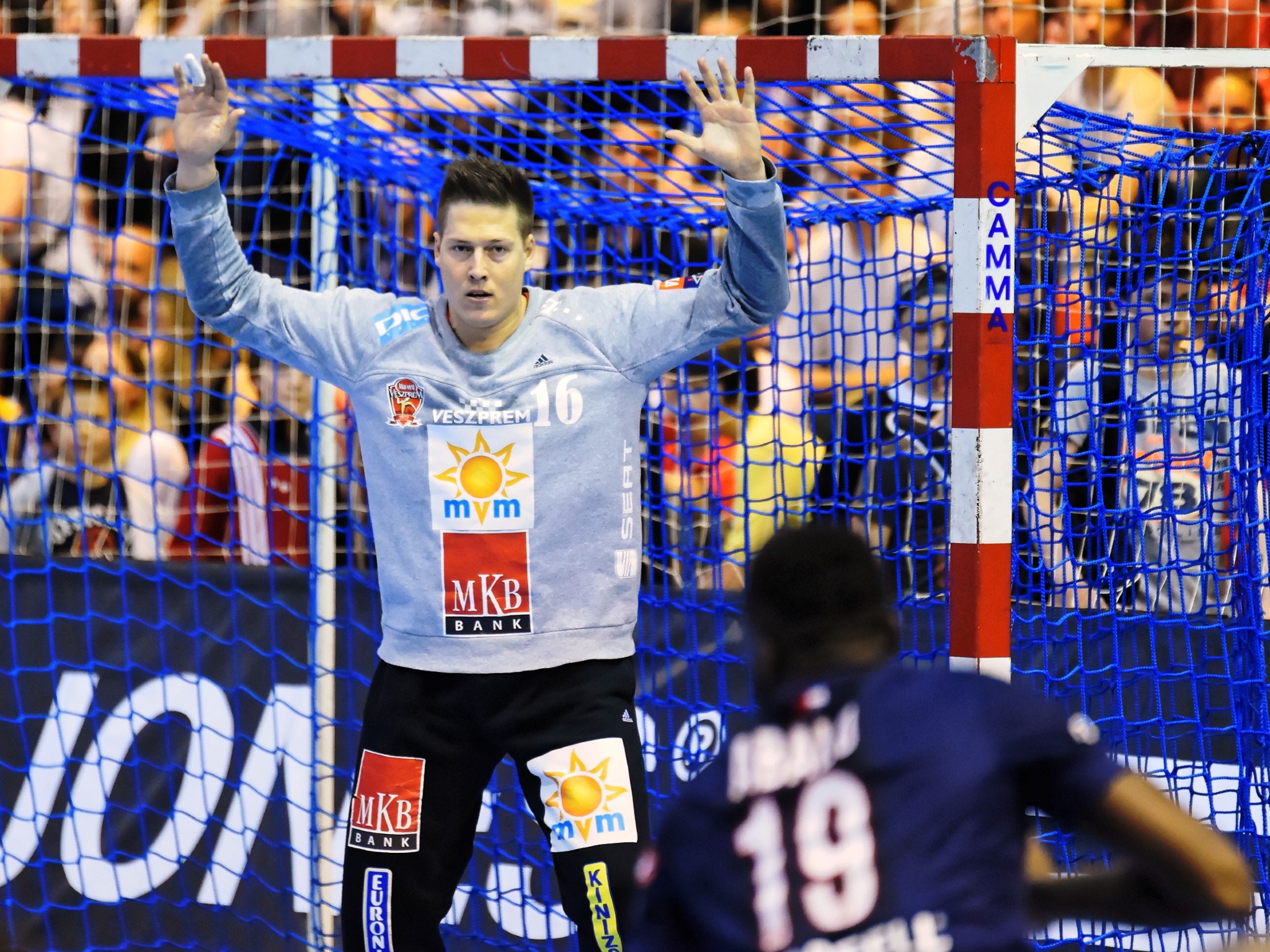 Handballspieler hebt Hände in der Nähe eines Tores bei der Futsal-Weltmeisterschaft 2019, mit Zuschauern und einem Banner im Hintergrund.