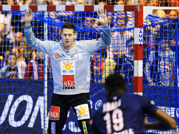 Handballspieler hebt Hände in der Nähe eines Tores bei der Futsal-Weltmeisterschaft 2019, mit Zuschauern und einem Banner im Hintergrund.
