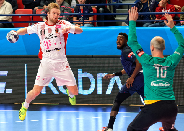 Männerhandballmannschaft während des Futsal-Weltmeisterschaftsspiels 2019 zwischen Bayern München und Paris Saint-Germain auf einem Feld, mit Zuschauern im Hintergrund.