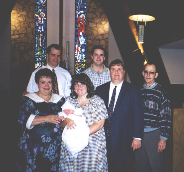 Eine Frau mit einem Baby in den Armen, mit einem hellen Licht im Hintergrund.