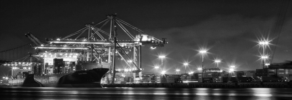 Ein Schiffbau mit Metallkonstruktionen, Laternen, Containern und Schiffen.