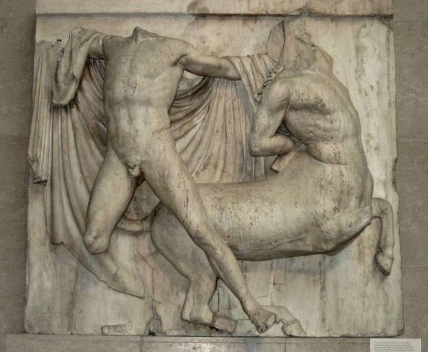 Skulpturen an einer Wand montiert mit Text am unteren Bildrand.