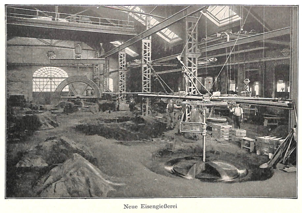 Schwarzes und weißes Foto eines Fabrikinneren mit Arbeitern, die Maschinen bedienen, umgeben von Metallstangen und - Polen, beschriftet mit "Neue Eisengießerei, die erste Fabrik in Deutschland" unten.