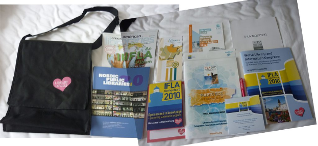 Eine Tasche mit der Aufschrift 'Bibliotheksliebhaber' und einige Bücher liegen auf einem Bett.