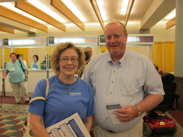 Menschen, die auf einem Boden mit einem Rollstuhl und einer Wand im Hintergrund stehen, unter einer Decke mit Lichtern.