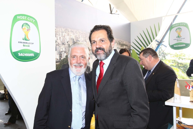 Eine Gruppe von Menschen, die mit einigen, die lächeln, und einem FIFA-Weltmeisterschaftsposter im Hintergrund steht.