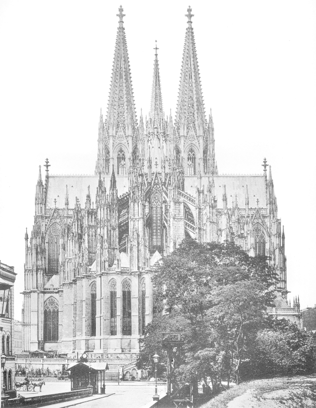Ein Schwarz-Weiß-Foto des Kölner Doms in Köln, Deutschland, ein majestätisches Gebäude mit hohen Türmen und detaillierten Verzierungen, umgeben von Bäumen, Straßenlaternen, Straßenlaternen und Menschen, die auf der Straße gehen, mit dem Himmel im Hintergrund.