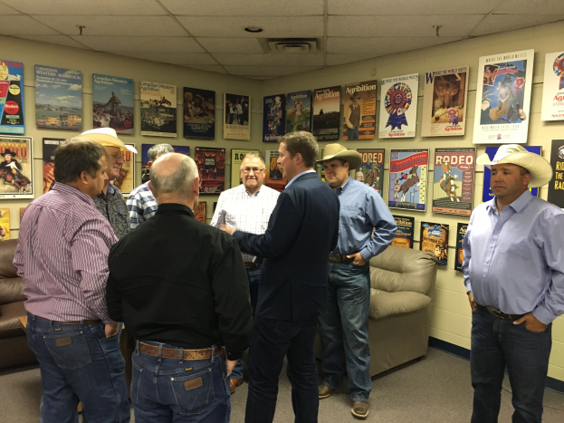 Gruppe von Männern in einem möblierten Raum in ein Gespräch vertieft.