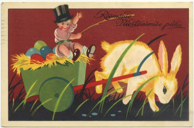 Alte Postkarte mit einem Baby in einem Zylinder, das einen Karren voller bunter Ostereier schiebt und von einem Hasen begleitet wird.