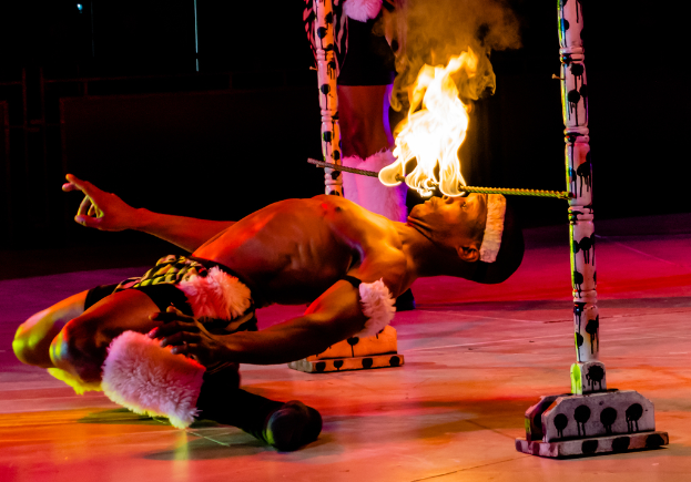 Eine Person schaut auf ein Feuer, das auf einem Stab befestigt ist, der an Stangen befestigt ist.